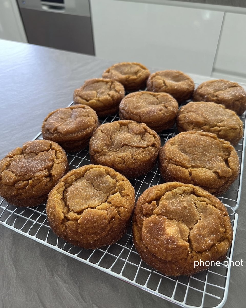 Warm gluten-free snickerdoodles stacked on a wire rack next to a glass of milk