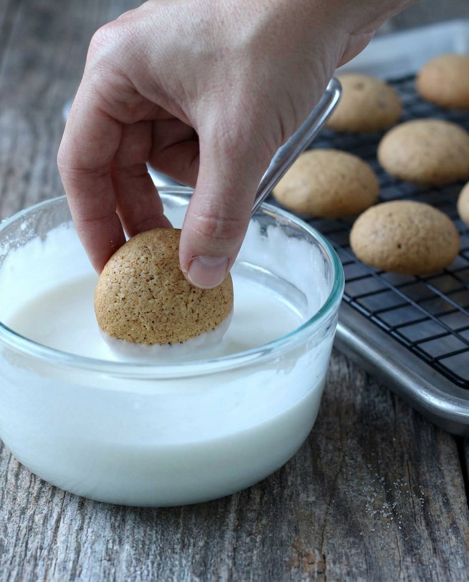 Small round balls of pfeffernusse dough arranged on a baking sheet.