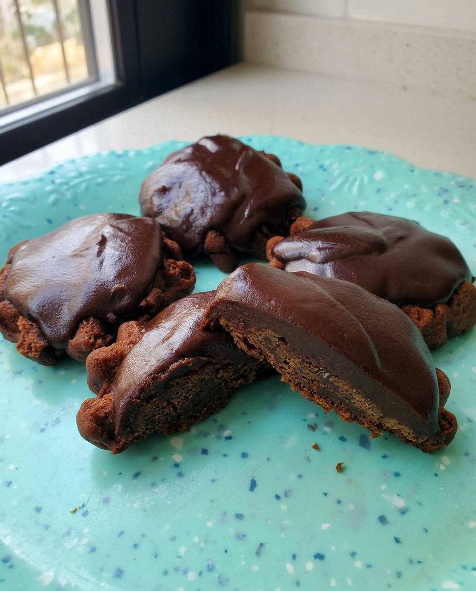 A giant chocolate turtle cookie being pulled apart to reveal a gooey caramel center