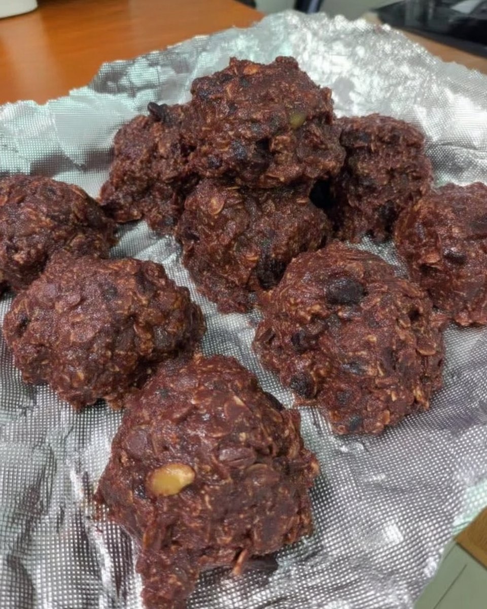 Finished no bake cookies cooling on waxed paper next to a wooden tray