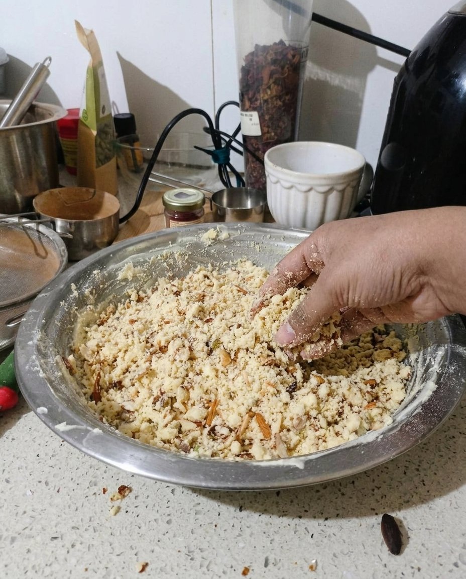 Hands rolling a ball of Naan Khatai dough