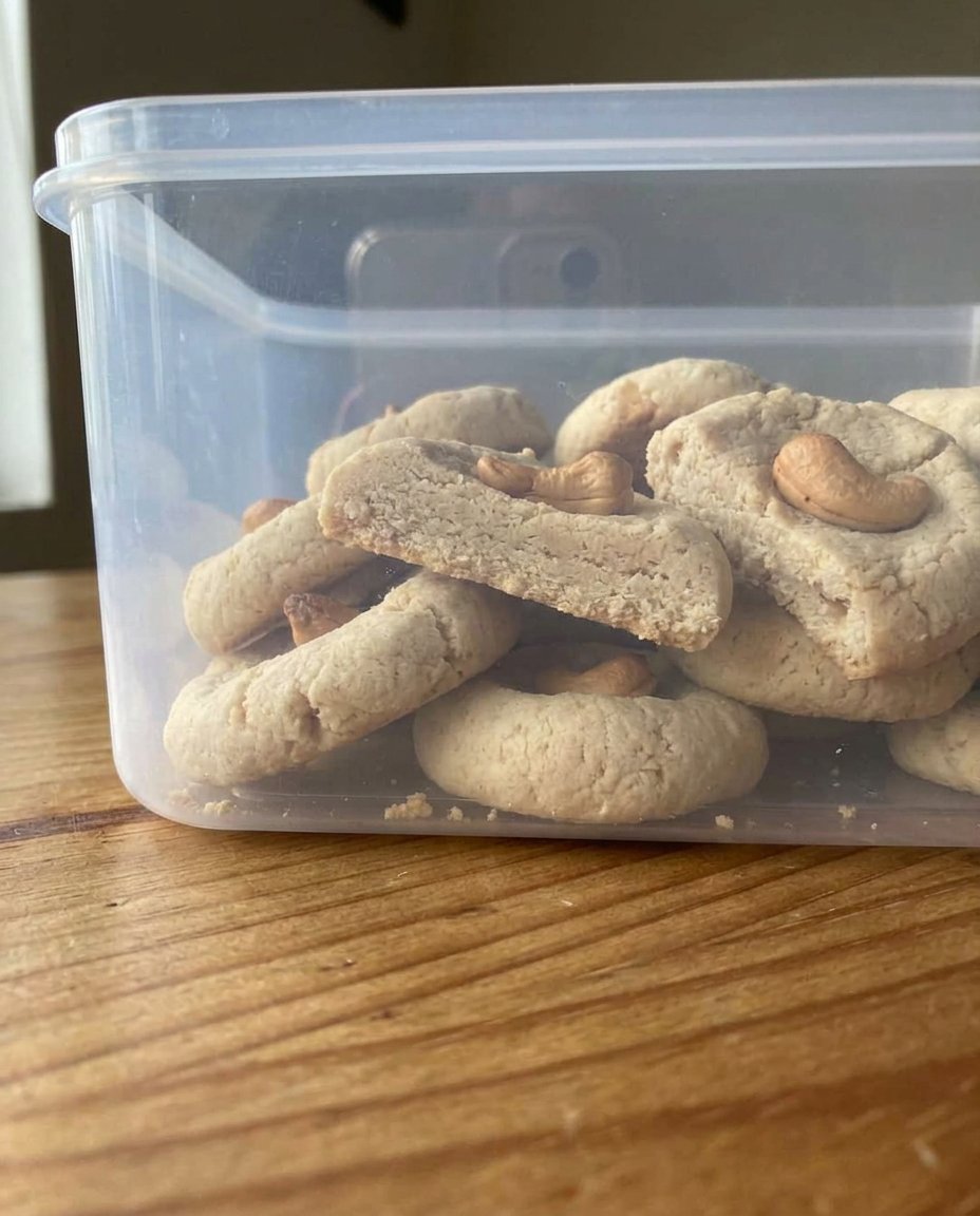 Cashew Shortbread 14 Cashew shortbread cookies arranged on a rustic wooden serving board next to a cup of tea.