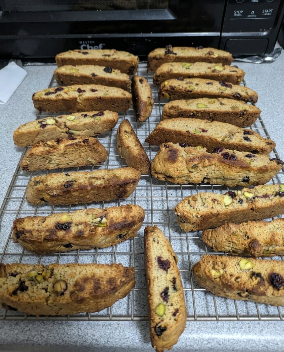 Golden brown cranberry pistachio biscotti slices on a cooling rack