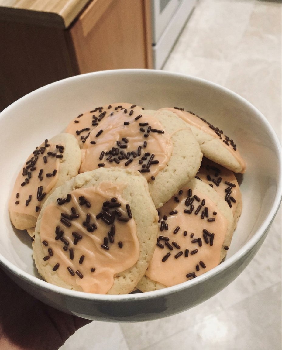 A stack of thick vegan sugar cookies with colorful icing and bright sprinkles